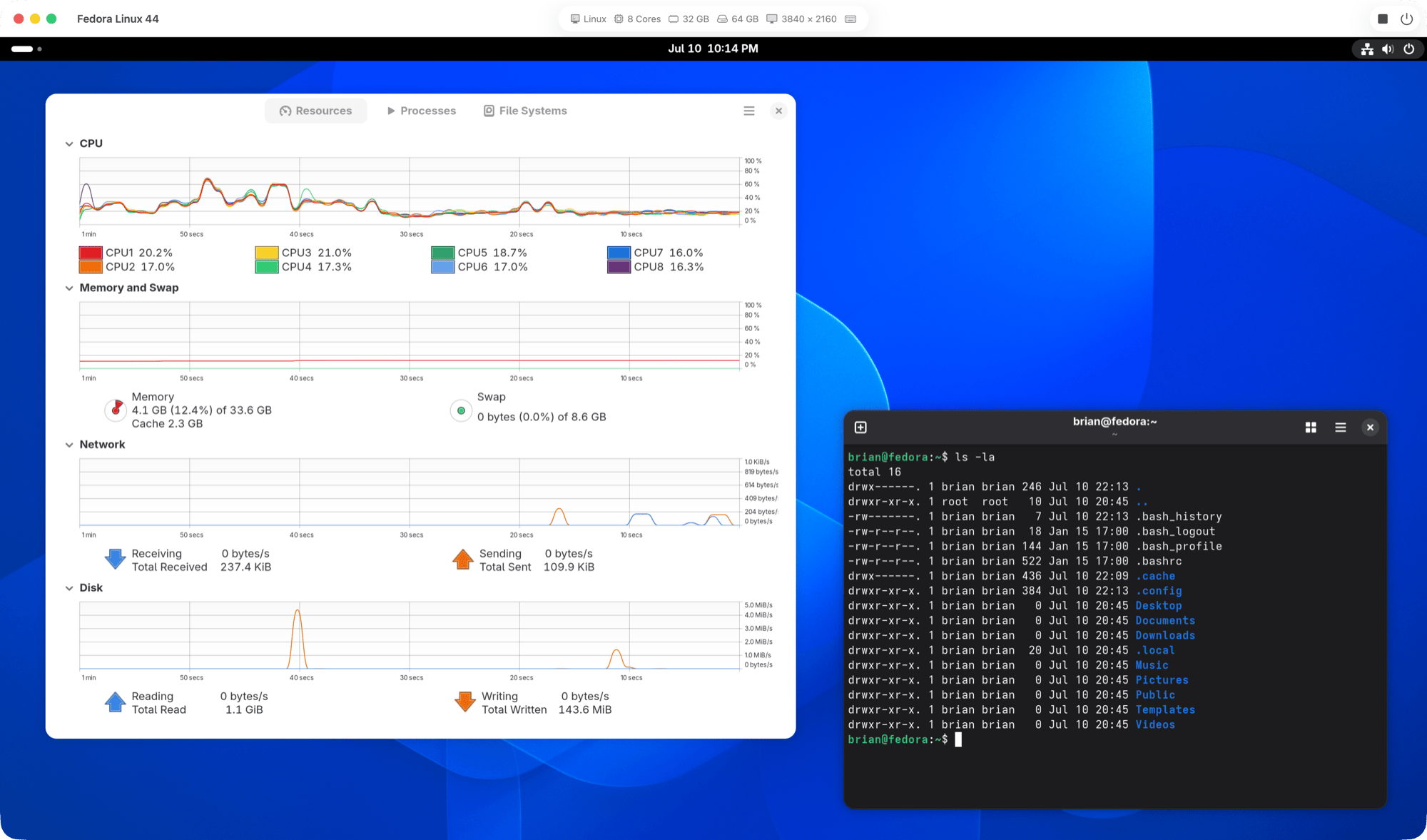 A running Fedora Linux virtual machine in MokaRig, showing the GNOME system monitor with live CPU, memory, and network graphs alongside a terminal.
